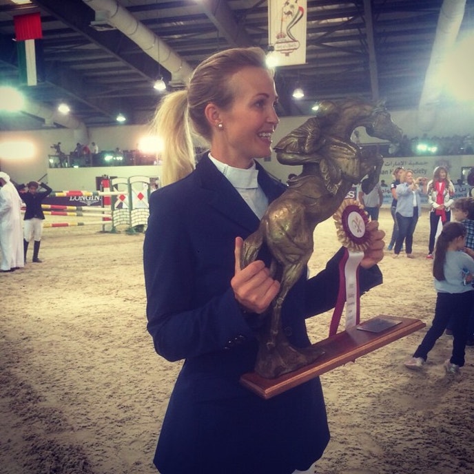 Tina Lund with an award in her hands as "Rider of the year" in 2014-2015 in the United Arab Emirates