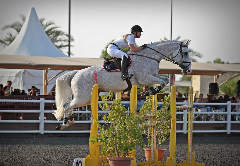 Tina Lund on the princess` of the United Arabian Emirates white horse during competition in Dubai captured while jumping