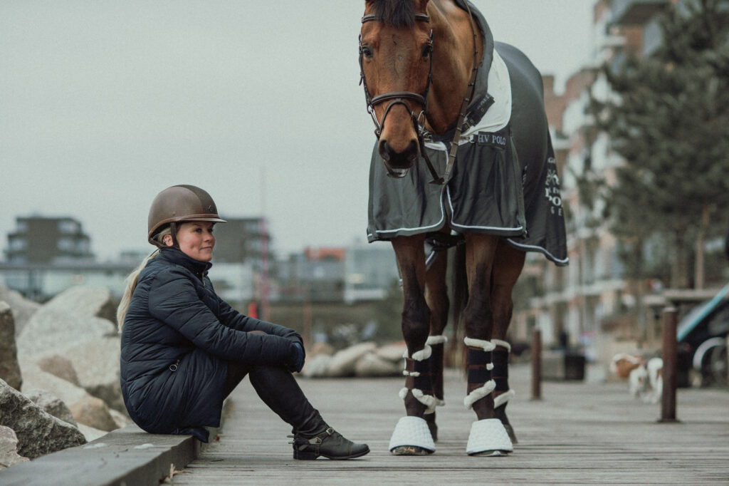 Vicky sitting and horse Warmblood standing