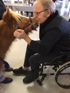 Henning kissing a man in a wheelchair